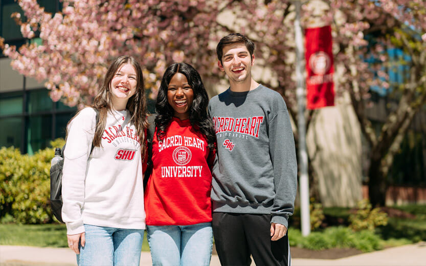 three students wearing Sacred Heart sweatshirts