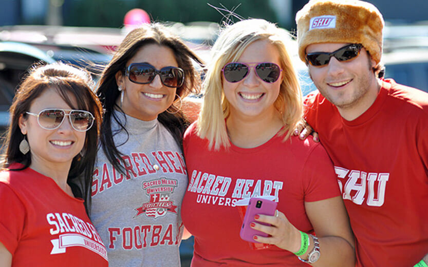 four students wearing sacred heart tshirts and wearing sunglasses