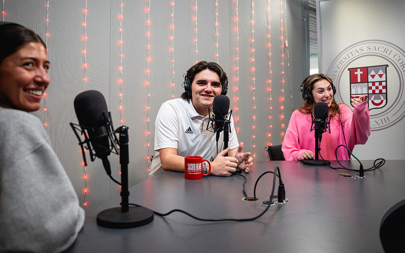 three students doing a podcast