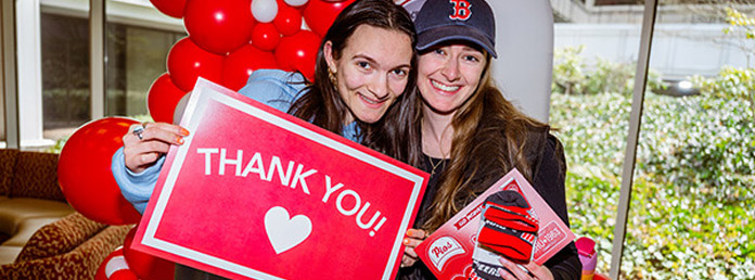 two female students holding a thank you sign