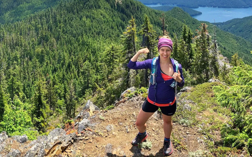 a woman hiking and making a strong sign with her arm