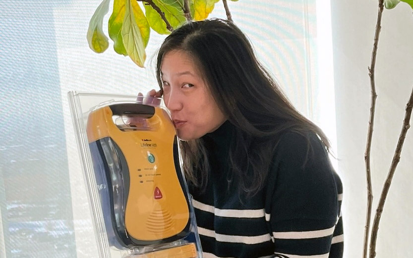 an asian woman kissing her emergency heart machine