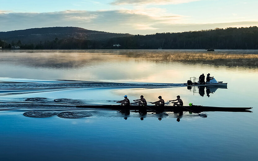 Crew team rowing at dawn
