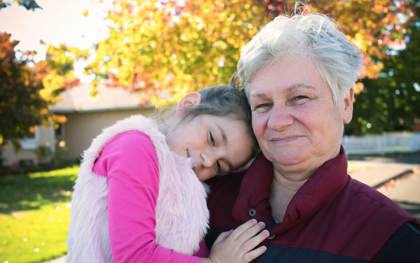 a grandmother holding her granddaughter and smiling
