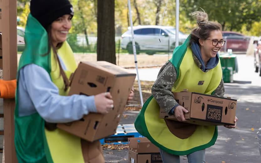 two volunteers dressed as avocados distributing food