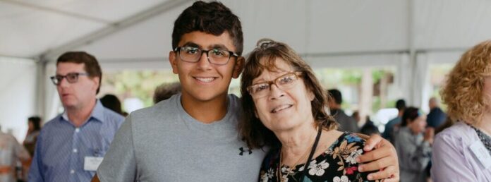 A teenage boy with his arm around an older woman