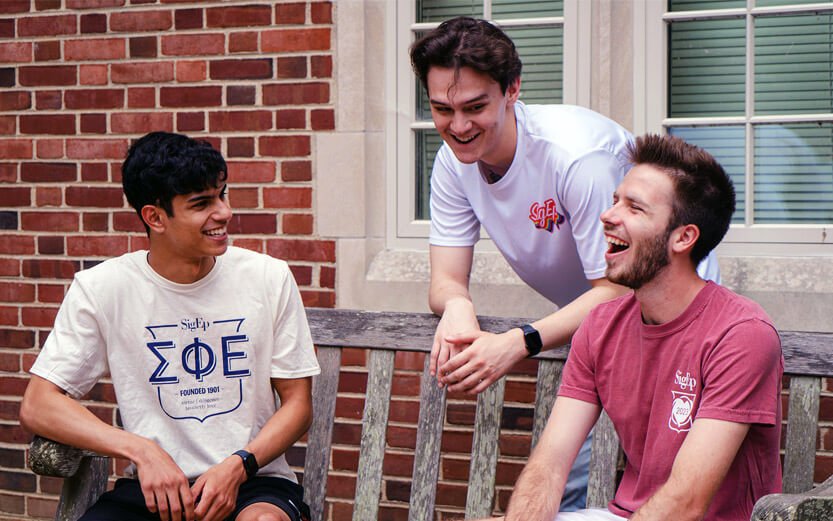 three Sigma Phi Epsilon members talking and laughing outside
