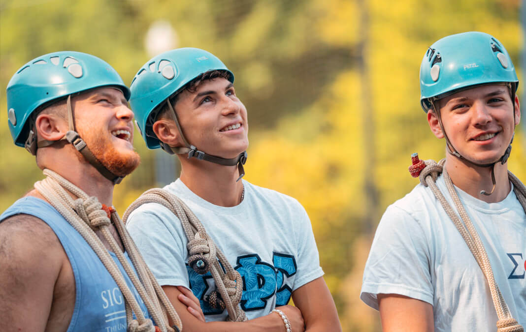 Sigma Phi Epsilon members wearing blue helmets getting ready for mountain climbing