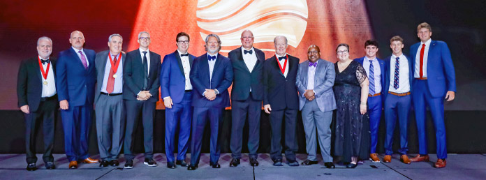 group of sig ep alumni wearing suits on stage