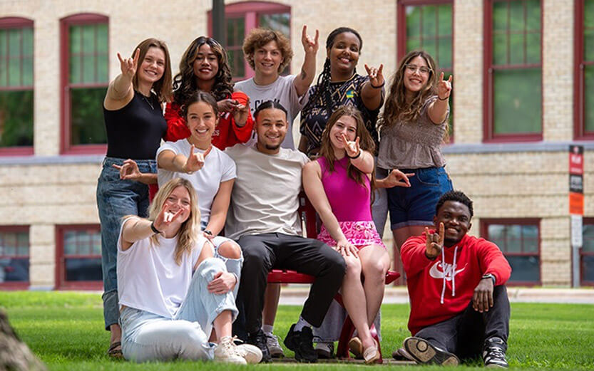 a group of students flashing the school hand signal