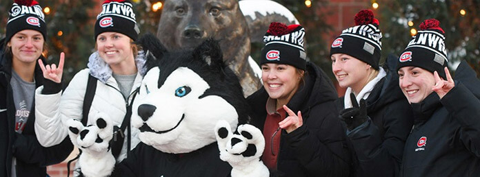 a group of five students with the school mascot posing for a photo
