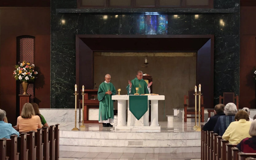 pastors at the front of the church wearing green robes