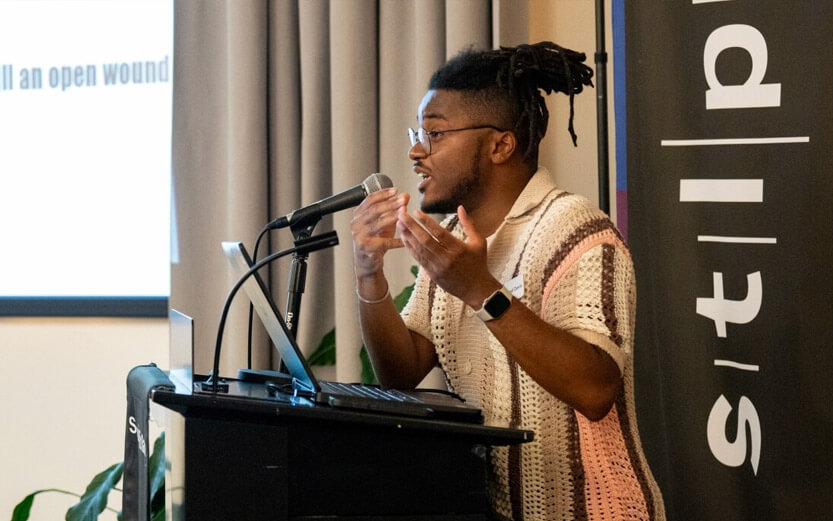 a man standing at a podium addressing an audience