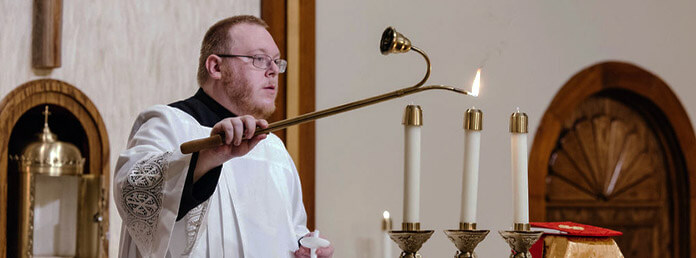 a church officiant lighting candles