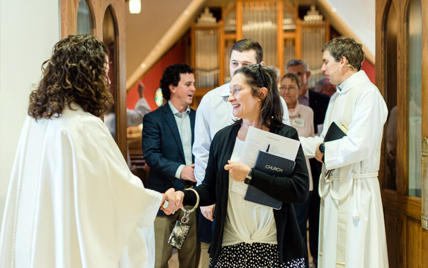 church members shaking hands with the pastor