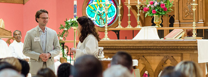 man and woman talking in the front of the church alter