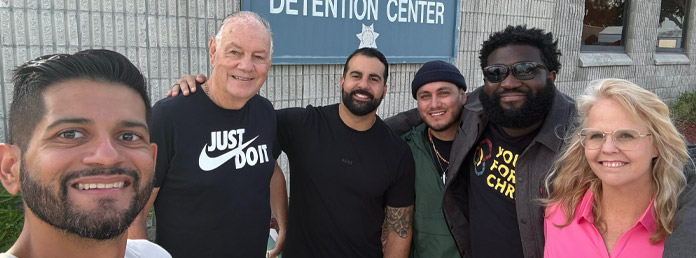 a group of people smiling in front of a juvenile detention center