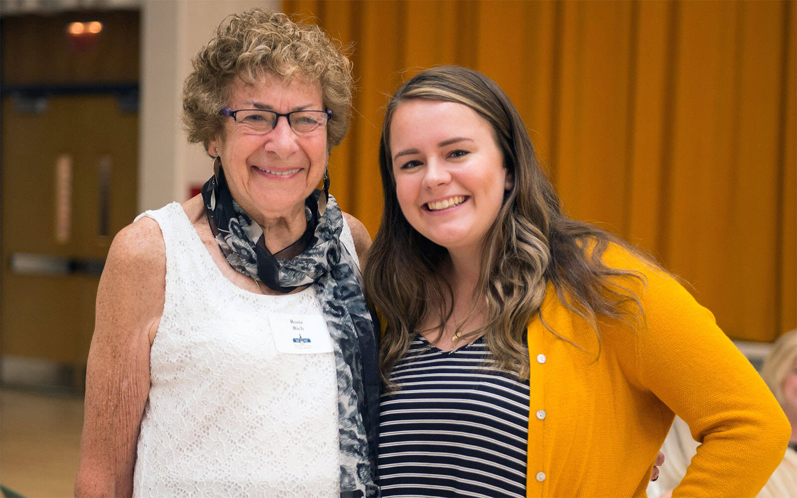 An older woman and a younger woman smiling