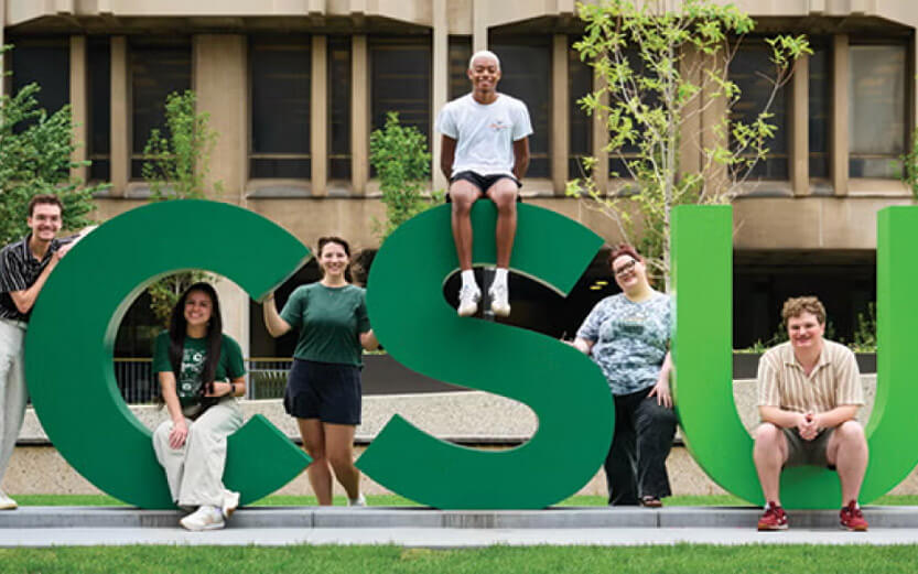 students posing on the CSU letter sculpture