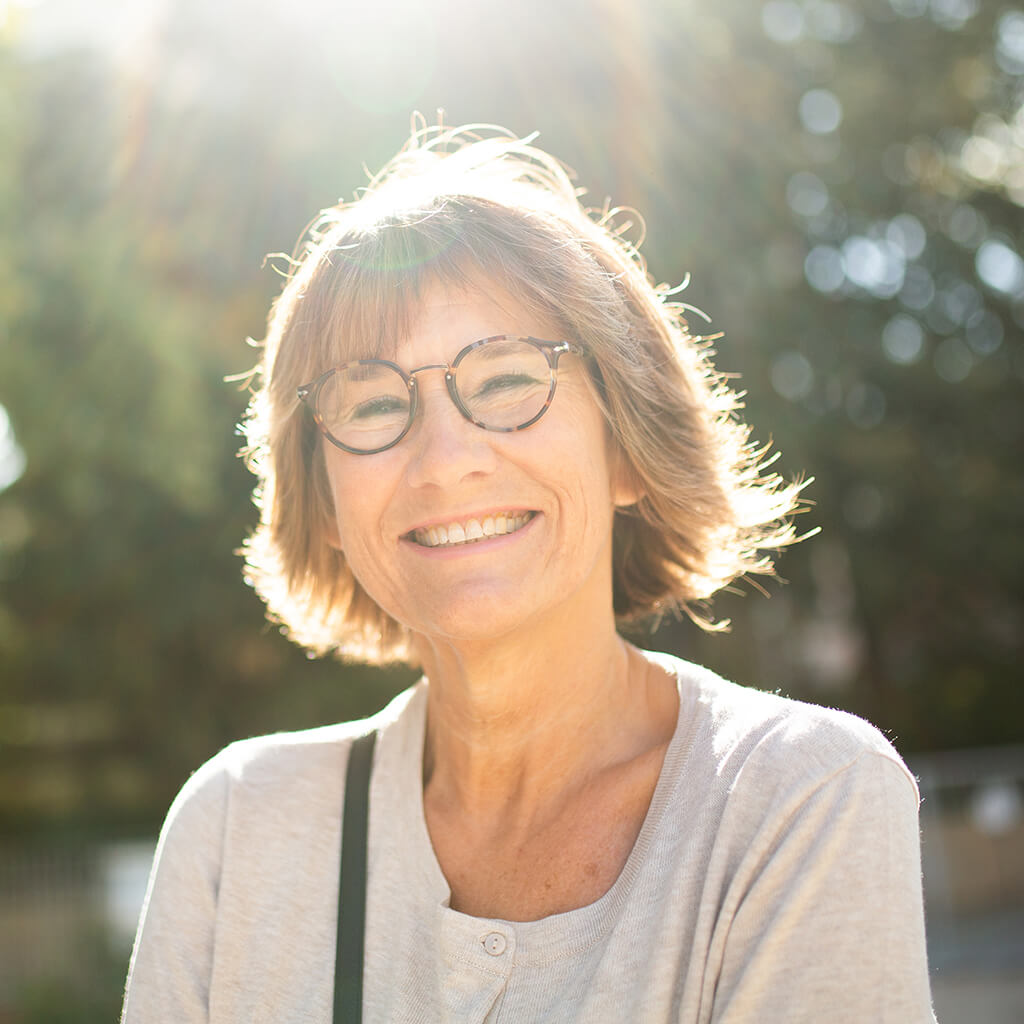 Close up portrait smiling older woman outside with glasses