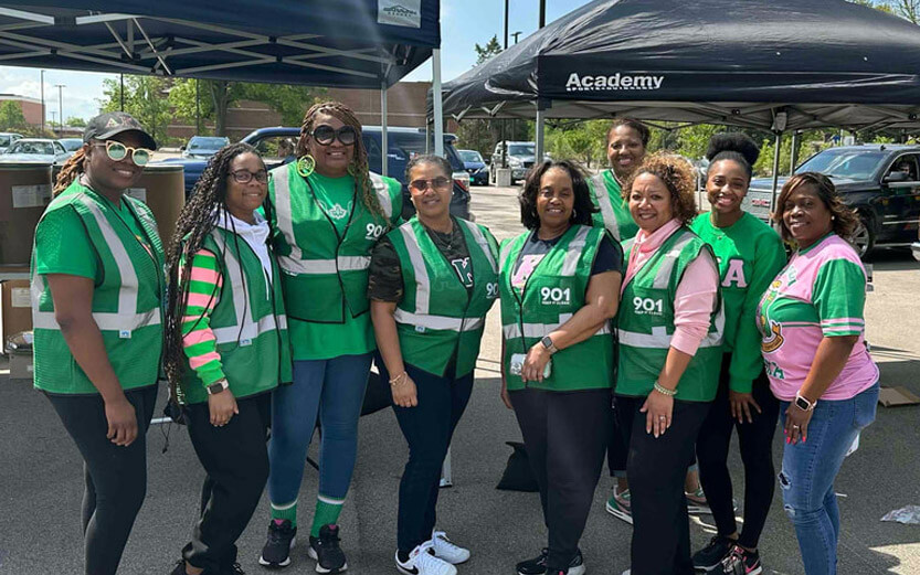 group of women wearing green vests