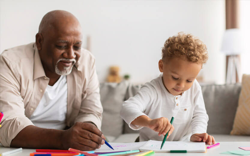 a grandfather coloring with markers with his grandson