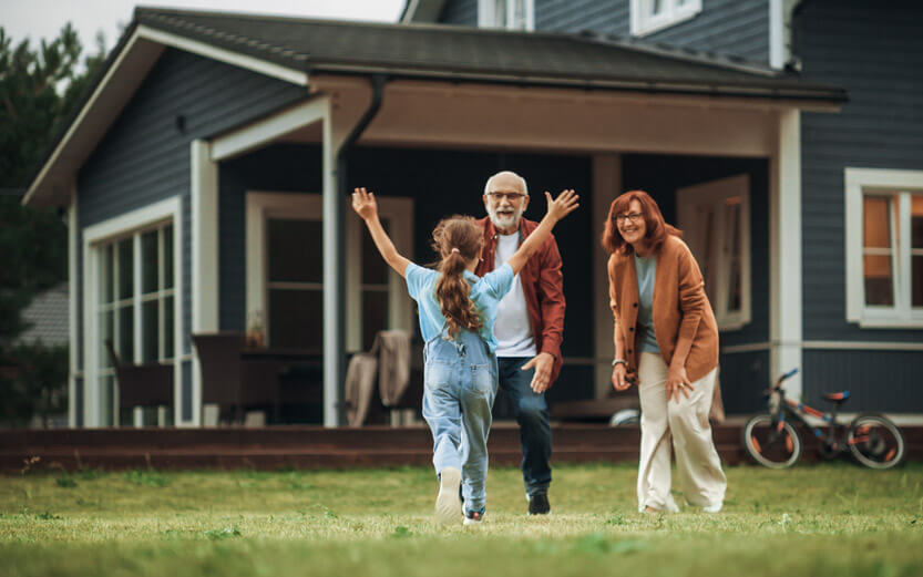 a young girl running to her grandparents with arms outstretched