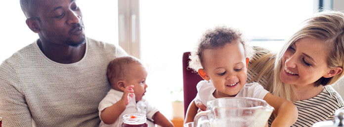 a couple at breakfast with their baby and toddler