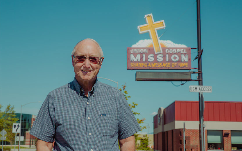 senior man outside with UGM sign in background