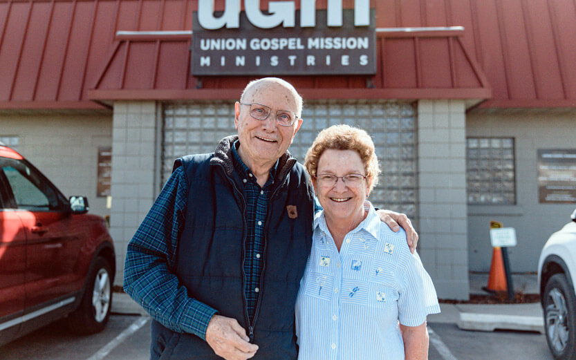 senior couple outside of mission smiling