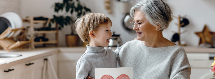 a grandmother talking to her young grandson in the kitchen