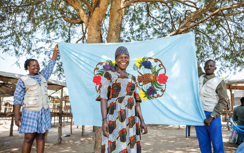 woman in front of a blue banner held by two other people
