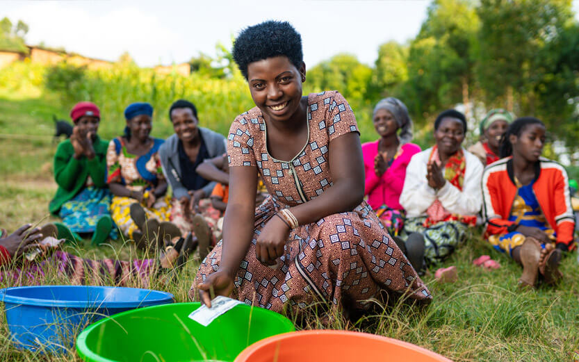 woman in foreground with colorful bins and a group of people sitting behind her