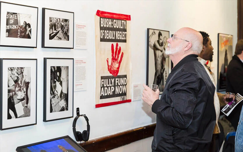 a senior man browsing art photos at an art gallery