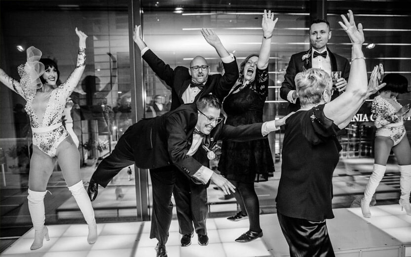 a black and white photo or people dancing at an LGBTQ+ fundraising event