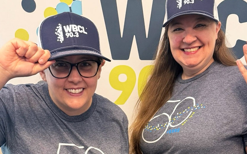 two women wearing baseball caps and tshirts commemorating 50 years