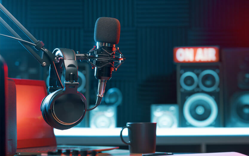 microphone and headphones with an On Air sign and speakers in the background