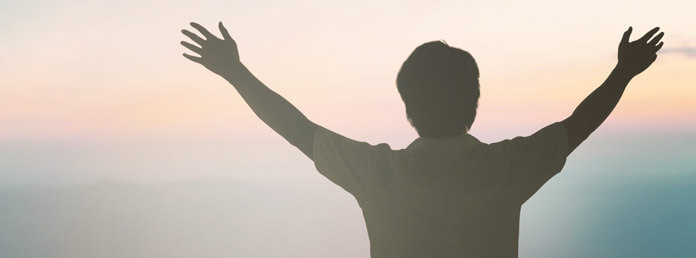 silhouette from the back of a man with outstretched arms