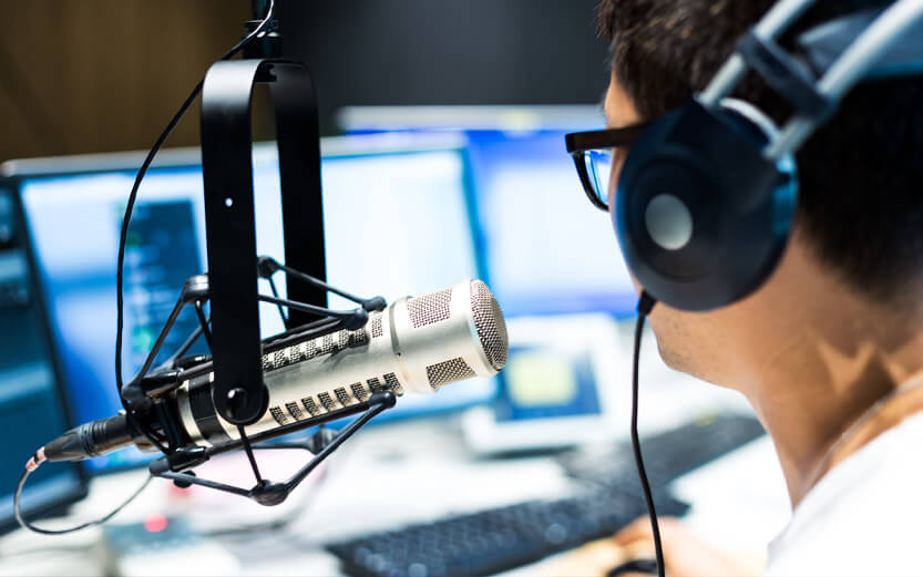 a dj with headphones talking into a microphone