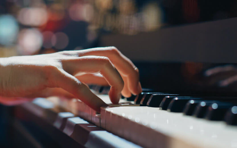 close up of hands playing piano