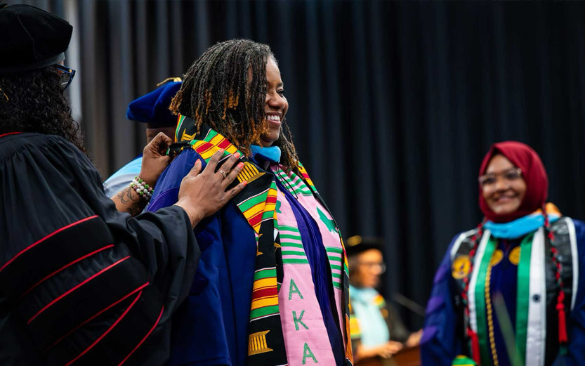 a woman receiving honors from a school professor