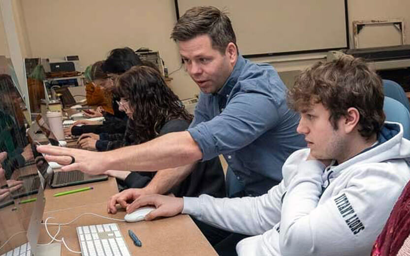 a teacher helping a student with work on their computer