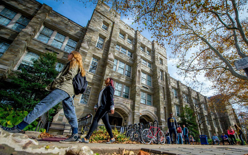 low angle shot of students walking in front of a school building