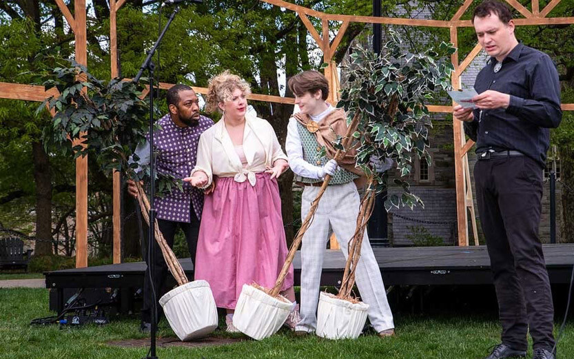 four theatre students performing a play