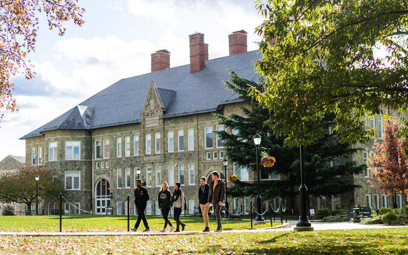 a WCU building with five students walking in the foreground