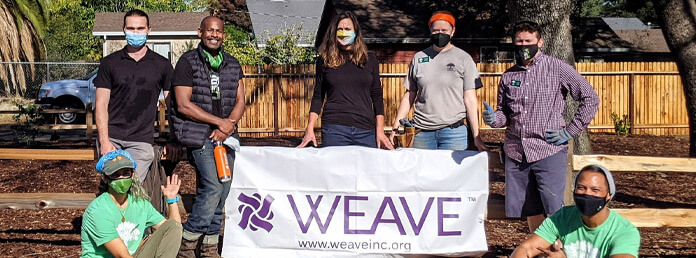 WEAVE volunteers with banner