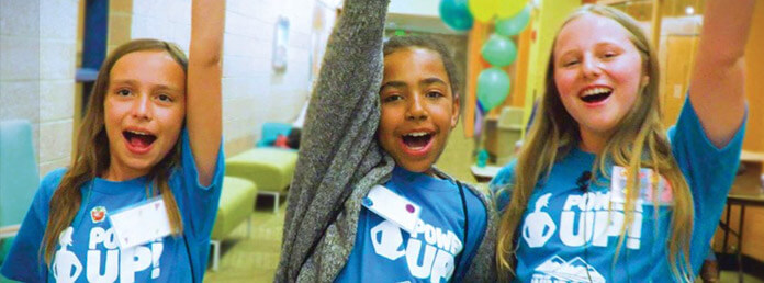 three girls in blue shirts cheering
