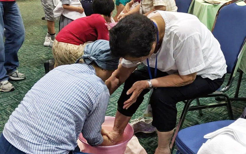 a woman washing the feet of another woman