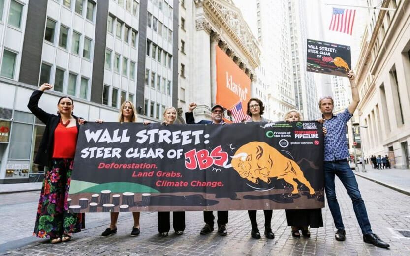 a group of protesters on wall street holding a sign
