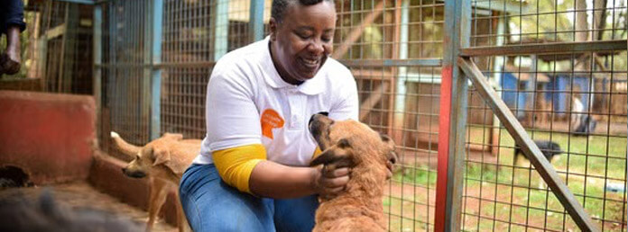 a woman smiling and petting a dog that was rescued